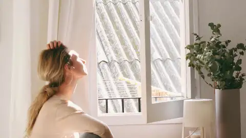 Imagen de archivo de una mujer recibiendo el sol por la mañana Imagen de archivo de una mujer recibiendo el sol por la mañana