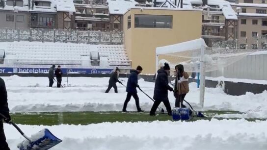 Jugadores y voluntarios retiran la nieve del campo del Andorra