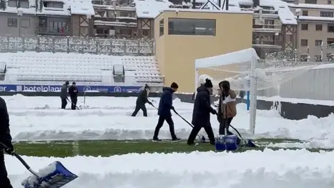 Jugadores y voluntarios retiran la nieve del campo del Andorra Jugadores y voluntarios retiran la nieve del campo del Andorra