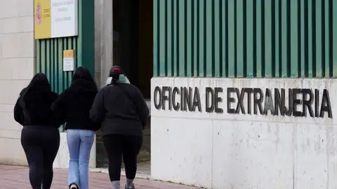 Personas pasean cerca de una oficina de extranjería en España Personas pasean cerca de una oficina de extranjería en España