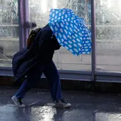 Una persona se protege de la lluvia. Una persona se protege de la lluvia.