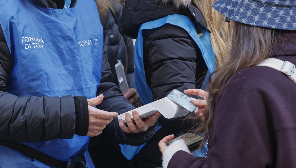Turistas pagando para acceder a la Fontana di Trevi. Turistas pagando para acceder a la Fontana di Trevi.