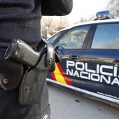Imagen de archivo de un agente y un coche de la Policía Nacional. Imagen de archivo de un agente y un coche de la Policía Nacional.