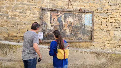 Dos personas mirando uno de los cuadros en Arcusa Dos personas mirando uno de los cuadros en Arcusa