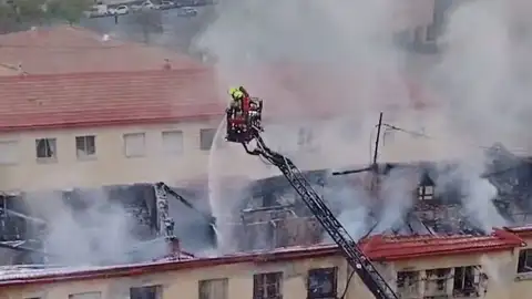 Los bomberos intentan apagar el fuego que se ha extendido al tejado Los bomberos intentan apagar el fuego que se ha extendido al tejado