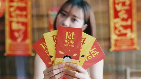 Mujer con los tradicionales sobres rojos del Tet Mujer con los tradicionales sobres rojos del Tet