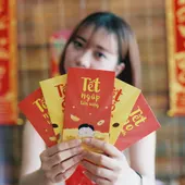 Mujer con los tradicionales sobres rojos del Tet Mujer con los tradicionales sobres rojos del Tet