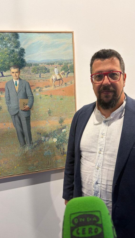 El comisario de la exposición, Gustavo Domínguez, ante el autoretrato de Sebastián García Vázquez en ARCO.