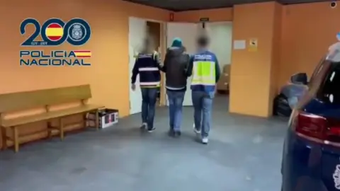 La policía escolta a uno de los arrestados La policía escolta a uno de los arrestados