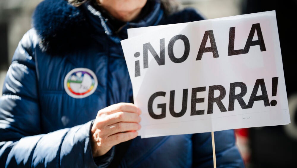 Una manifestante porta un cartel durante la protesta en Madrid contra la guerra en Irán 