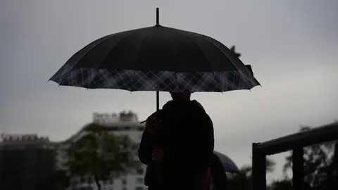 Peatones se protegen de la lluvia bajo sus paraguas. Peatones se protegen de la lluvia bajo sus paraguas.