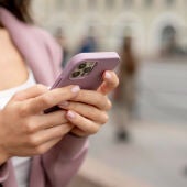 Mujer sostiene un teléfono móvil 