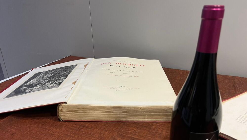 Ejemplar de el Quijote junto a una botella de vino manchego