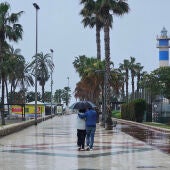 Varias personas pasean por el paseo marítimo de Torre del Mar, en Vélez-Málaga.