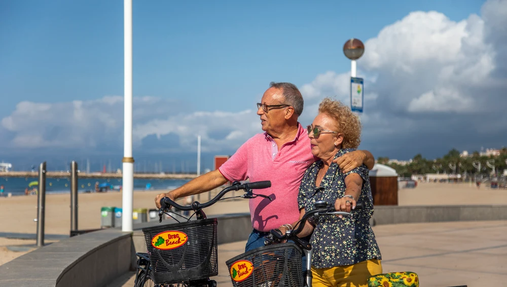 Una pareja monta en bici por el paseo marítimo Una pareja monta en bici por el paseo marítimo