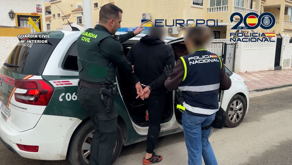 Agentes de la Guardia Civil y la Policía Nacional con uno de los detenidos en la operación.