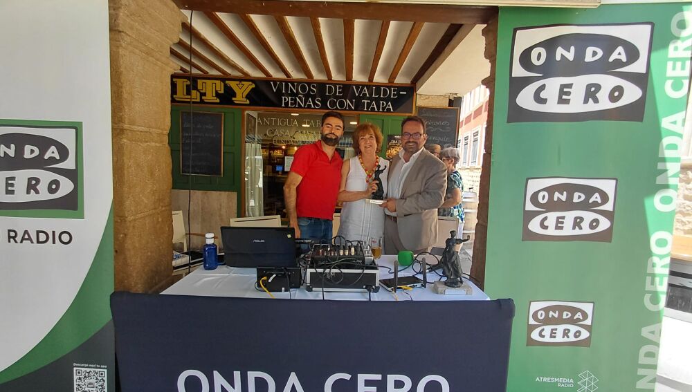 La escritora Cristina Galán recibe el reconocimiento Héroes 2026 de manos del director regional de OC CLM, Javier Ruiz, y el periodista Emilio Hidalgo