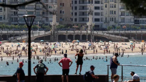 Bañistas disfrutan de un día veraniego en la bahía de la Concha de San Sebastián