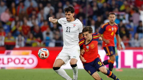 El centrocampista espa&ntilde;ol Gavi disputa un bal&oacute;n ante Marko Farji (i) de la selecci&oacute;n iraqu&iacute; durante el partido amistoso 