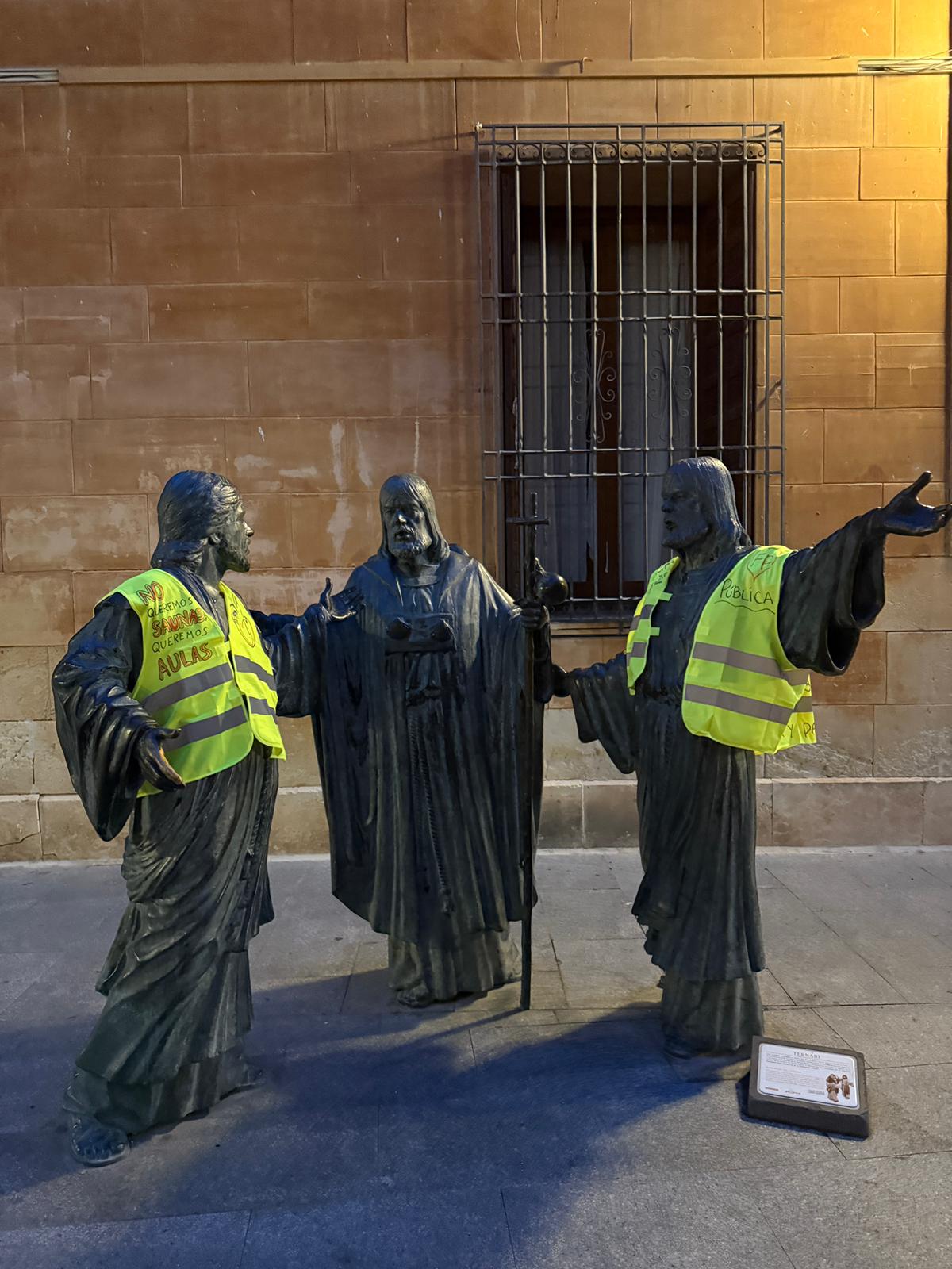 Los profesores de Elche visten con chalecos amarrillos las estatuas de la ciudad antes de suspender la huelga Los profesores de Elche visten con chalecos amarrillos las estatuas de la ciudad antes de suspender la huelga