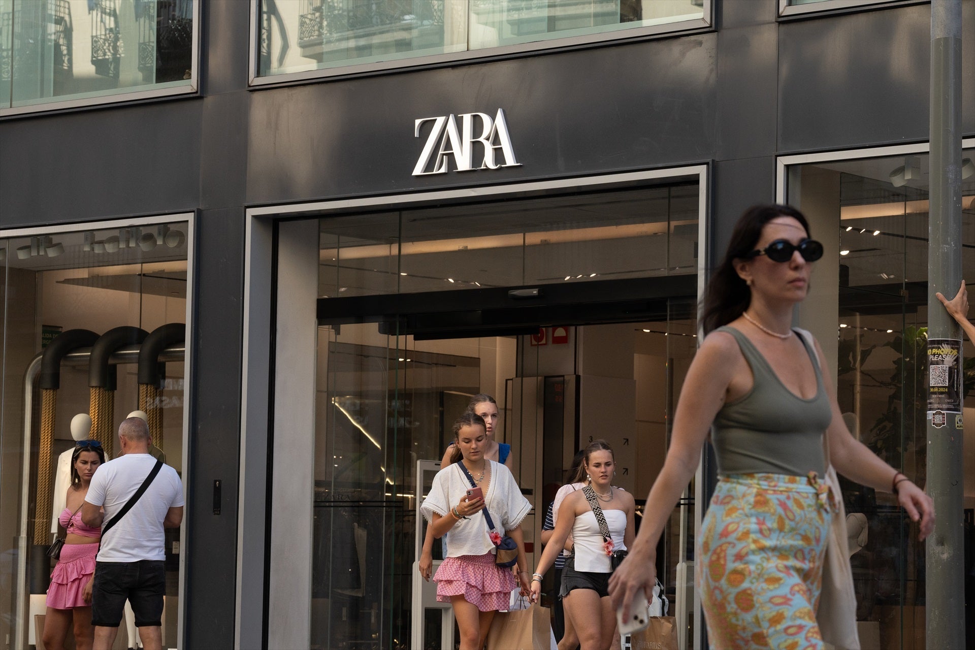 Varias personas pasan delante de una tienda Zara, en el centro de Barcelona, Varias personas pasan delante de una tienda Zara, en el centro de Barcelona,