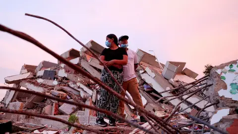 Una mujer y su esposo permanecen sobre los escombros mientras aguardan noticias de los equipos de rescate que buscan a sus hijos bajo los restos Una mujer y su esposo permanecen sobre los escombros mientras aguardan noticias de los equipos de rescate que buscan a sus hijos bajo los restos/ REUTERS/Ricardo Arduengo