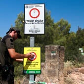 Un agent rural tancant l'accés a un camí forestal