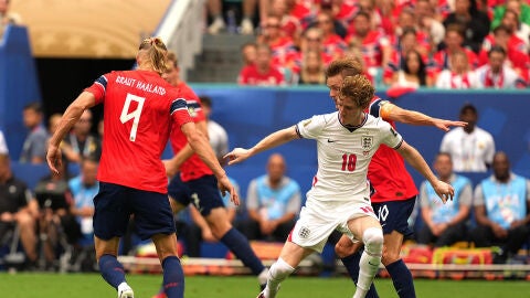 Martin Odegaard (d-atrás) y Erling Haaland (i) de Noruega disputan el balón con Anthony Gordon (c) de Inglaterra