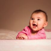 Bebé Sonriente Acostado En La Cama En La Habitación /Pexels