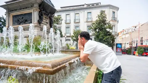 Un hambre se refresca en una fuente en Granada. Un hambre se refresca en una fuente en Granada.