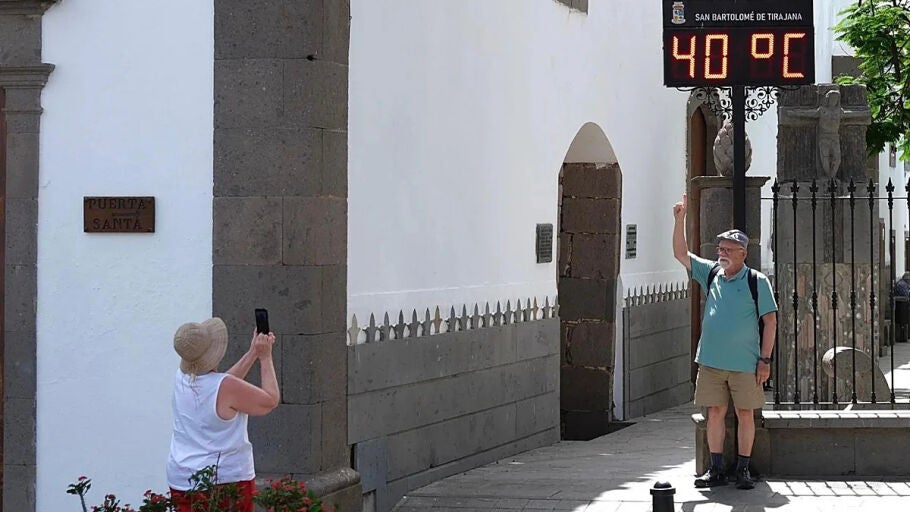 Un turista posa ante el term&oacute;metro que marca 40 grados en Tunte. (Juan Carlos Alonso)