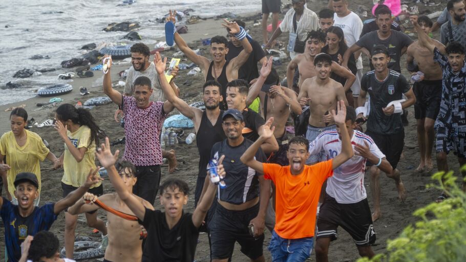Decenas de migrantes celebran haber traspasado la frontera entre Ceuta y Marruecos.