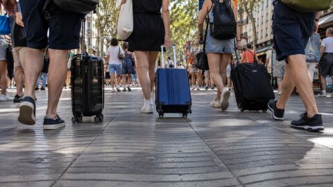 Un grup de turistes estiba maletes Rambla amunt, a Barcelona Un grup de turistes estiba maletes Rambla amunt, a Barcelona