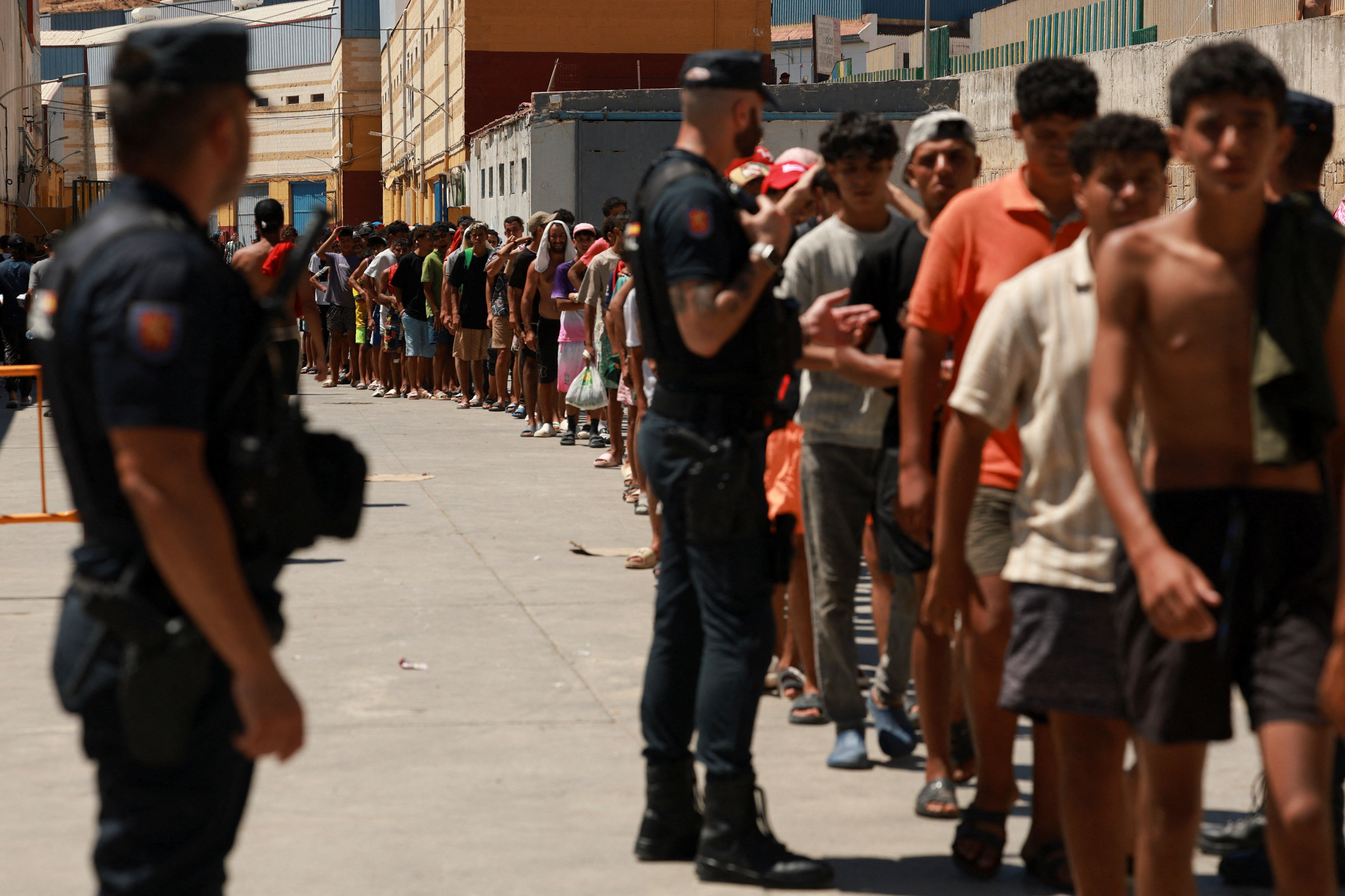 Migrantes esperan en fila para recoger comida en Ceuta. Migrantes esperan en fila para recoger comida en Ceuta.