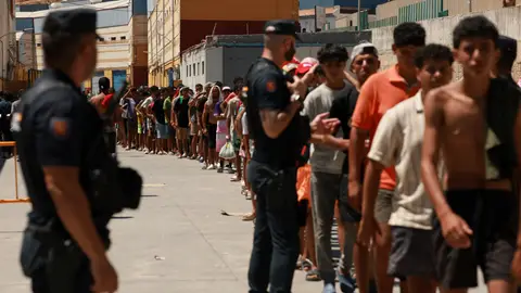 Migrantes esperan en fila para recoger comida en Ceuta. Migrantes esperan en fila para recoger comida en Ceuta.