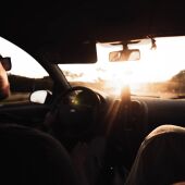 Imagen de archivo de una persona conduciendo durante un atardecer