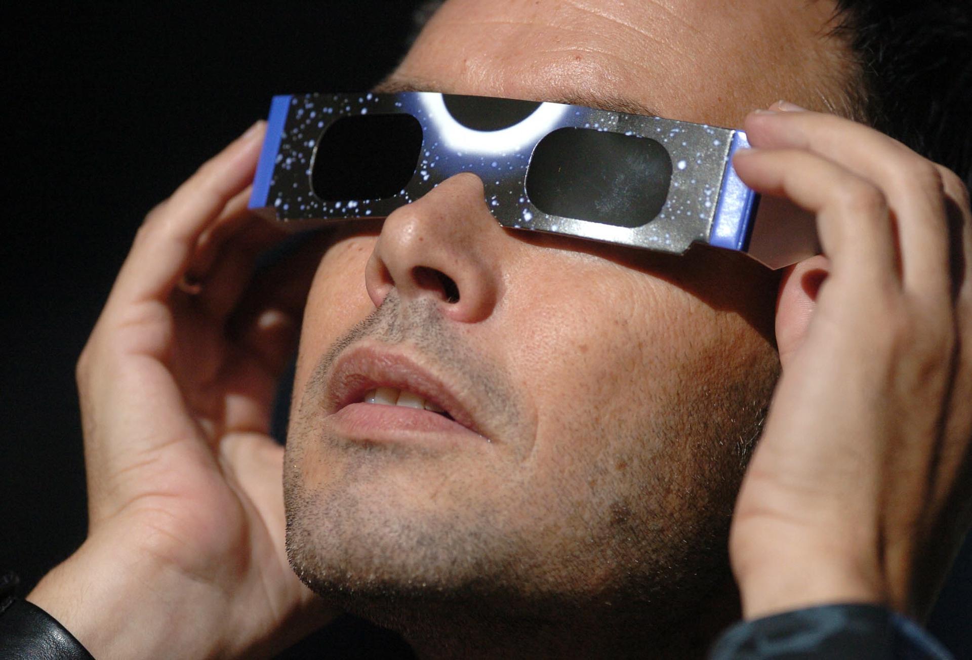 Imagen de archivo de un hombre con unas gafas para ver un eclipse solar. Imagen de archivo de un hombre con unas gafas para ver un eclipse solar.
