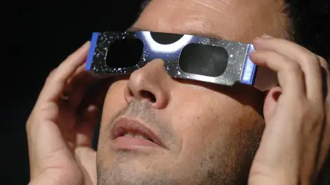 Imagen de archivo de un hombre con unas gafas para ver un eclipse solar. Imagen de archivo de un hombre con unas gafas para ver un eclipse solar.