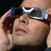Imagen de archivo de un hombre con unas gafas para ver un eclipse solar.