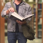 Joven leyendo un libro en una biblioteca Joven leyendo un libro en una biblioteca