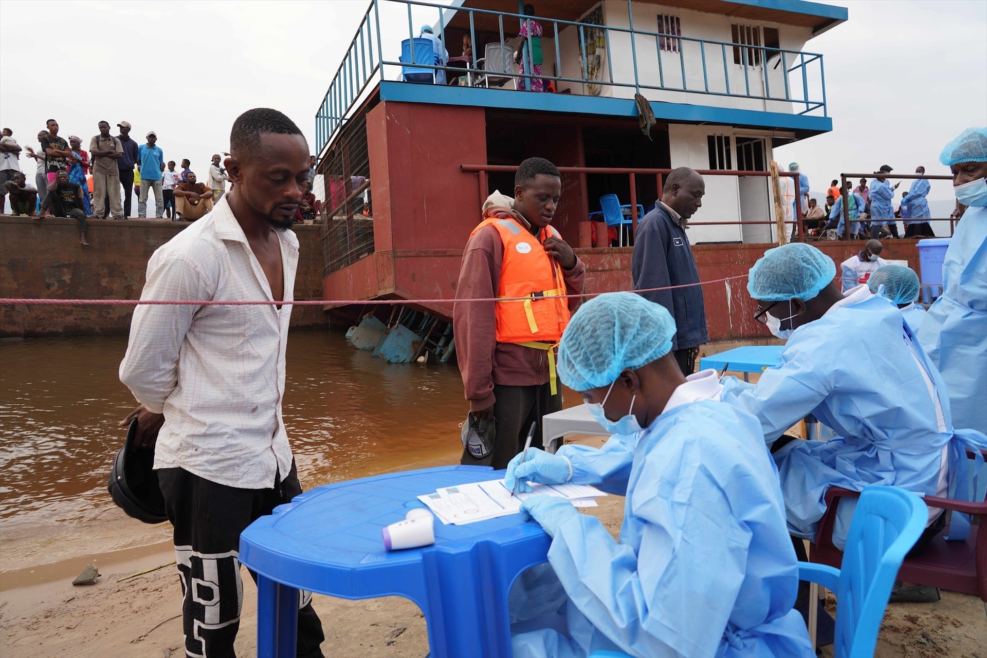 Los funcionarios sanitarios registran los datos de los pasajeros de una embarcación interceptada en las afueras de Kinshasa, capital de la República Democrática del Congo (RDC) Los funcionarios sanitarios registran los datos de los pasajeros de una embarcación interceptada en las afueras de Kinshasa, capital de la República Democrática del Congo (RDC)