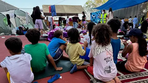 Menores sentados en uno de los puntos de ayuda de Ceuta. Menores sentados en uno de los puntos de ayuda de Ceuta.