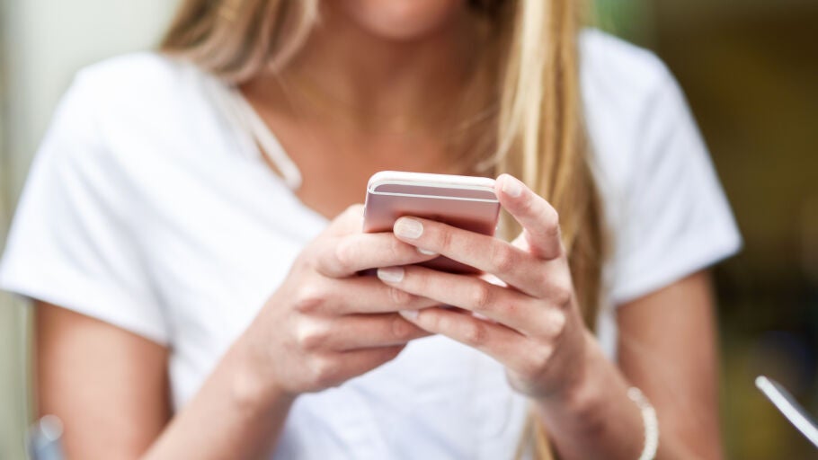 Imagen de primer plano de joven rubia chica mensajes de texto con smartphone