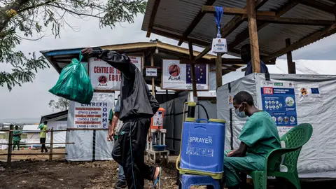 Ebola survivors leave the ALIMA Ebola Treatment Center at Rwampara General Hospital following their recovery from the disease, as a health worker sits beside a disinfectant sprayer and disinfects their shoes during discharge procedures on June 16, 2026 in Rwampara near Bunia, Democratic Republic of Congo. Ebola survivors leave the ALIMA Ebola Treatment Center at Rwampara General Hospital following their recovery from the disease, as a health worker sits beside a disinfectant sprayer and disinfects their shoes during discharge procedures on June 16, 2026 in Rwampara near Bunia, Democratic Republic of Congo.
