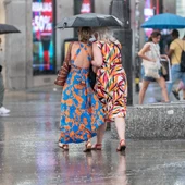 People cover themselves from rain with umbrellas during a summer storm coinciding with the second heat wave of the summer. People cover themselves from rain with umbrellas during a summer storm coinciding with the second heat wave of the summer.
