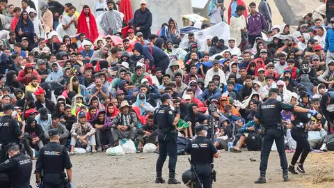La policía vigila a migrantes en las inmediaciones de la playa del Trampolín en Ceuta. La policía vigila a migrantes en las inmediaciones de la playa del Trampolín en Ceuta.