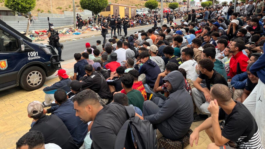 Migrantes frente a la explanada de embotellamiento de Loma Colmenar