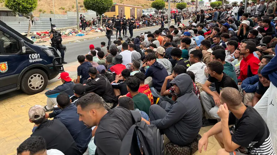Migrantes frente a la explanada de embotellamiento de Loma Colmenar Migrantes frente a la explanada de embotellamiento de Loma Colmenar
