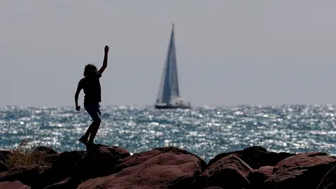 Archivo. Un niño corre por el espigón de una playa. Archivo. Un niño corre por el espigón de una playa.