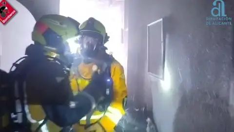 Bomberos en el interior del edificio de Elche en el que se ha registrado el incendio. Bomberos en el interior del edificio de Elche en el que se ha registrado el incendio.